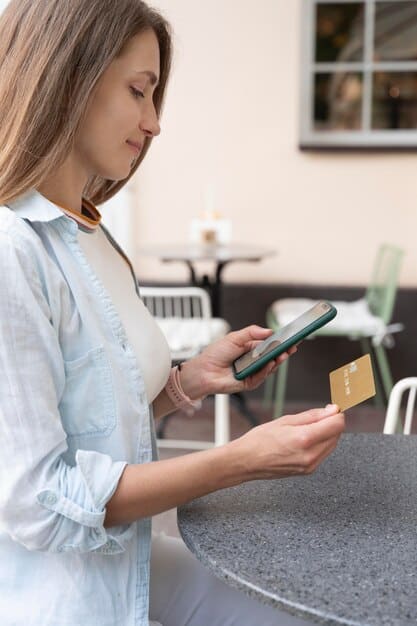 A person using a smartphone to make a contactless payment at a retail store. The point-of-sale (POS) system is displaying the confirmation of the transaction, and the store employee is smiling, illustrating the ease and convenience of mobile payments.