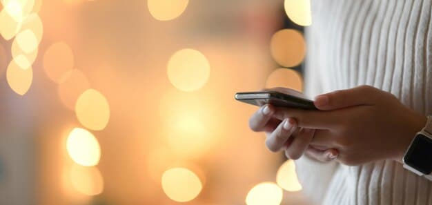 A close up of hands using a smartphone to complete a digital payment. The background is blurred, focusing on the phone and hands.