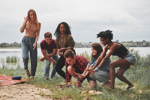An image depicting a diverse group of employees participating in a team-building activity outdoors, such as a ropes course or a collaborative game, showcasing a company culture that values teamwork, communication, and employee engagement within the fintech startup.