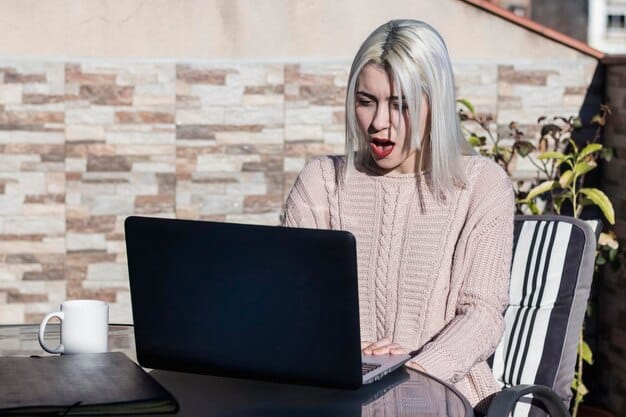 An employee looking suspiciously at an email on their computer screen, with a worried expression. The email has elements that suggest it might be a phishing attempt, such as a mismatched sender address and urgent call to action. The background shows a typical office cubicle setting.
