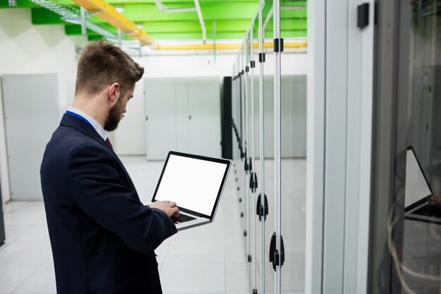 A cybersecurity professional inspecting a server rack with a tablet that is displaying a network diagram, indicating the process of identifying affected systems during a cyber attack.